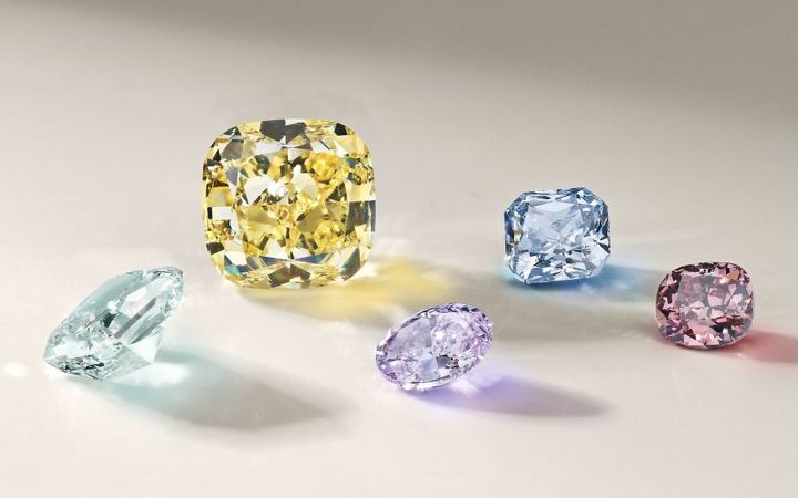 A group of colored diamonds featuring pale green, yellow, purple, blue and red stones